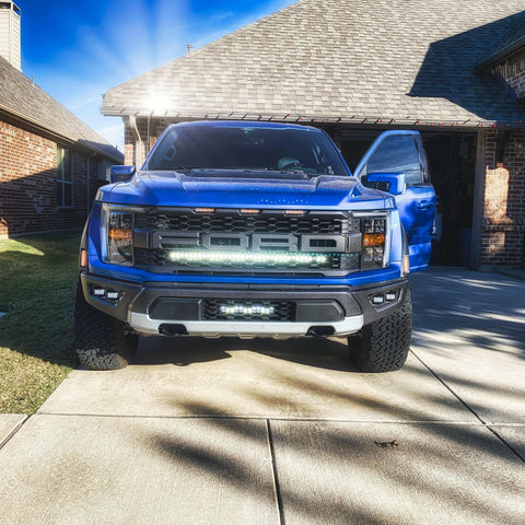 blue 2021 2022 2023 ford raptor generation 3 with one white light bar behind the grille 