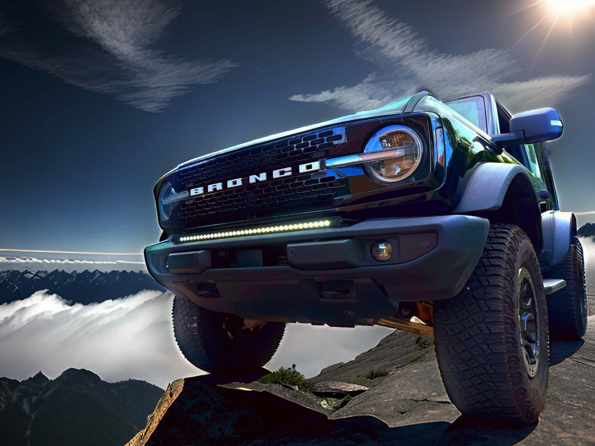 Standing on the Edge: Ford Bronco Standard Bumper - rugged Ford Bronco on a rocky mountain edge with sunlight