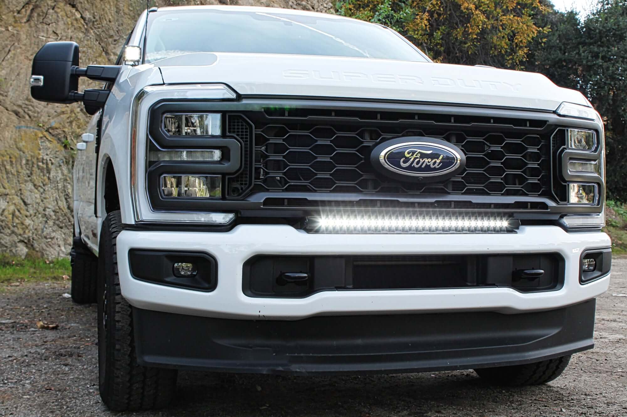 Upgrading Your 2023 Ford Superduty with LED Lights - front view of a white Ford Super Duty truck with LED light bar under grille