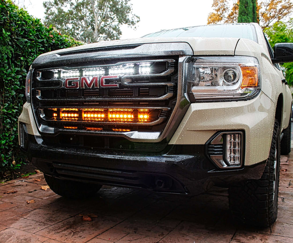 2022 2023 2024 tan GMC Canyon with white 30in and amber 40in light bars behind the grille for off roading by M&R automotive