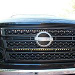 black nissan titan front view with off road led light bars behind the grille