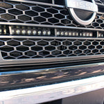 up close view of grille on nissan titan with one led light bar behind the grille in for off roading below the nissan logo
