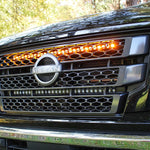 black nissan titan with one led light bar behind the grille in amber color for off roading