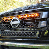 black nissan titan with one led light bar behind the grille in amber color for off roading