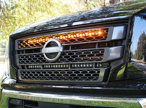 black nissan titan with one led light bar behind the grille in amber color for off roading