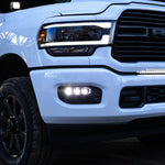 RAM 2500 Fog Light Kit installed on white RAM 2500 truck with illuminated LED fog lights at dusk