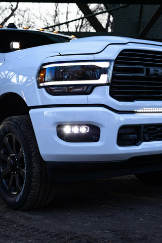 RAM 2500 Fog Light Kit installed on white RAM 2500 truck with illuminated LED fog lights at dusk