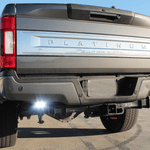 Ford Super Duty reverse light on 2020-2022 F250 F350 F450 rear view, chrome Ford badge, dual exhaust, lifted truck with flood reverse light