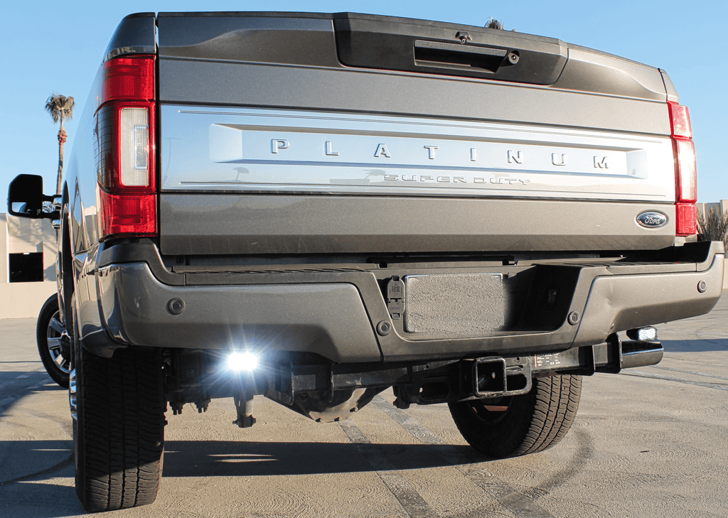 Ford Super Duty reverse light on 2020-2022 F250 F350 F450 rear view, chrome Ford badge, dual exhaust, lifted truck with flood reverse light
