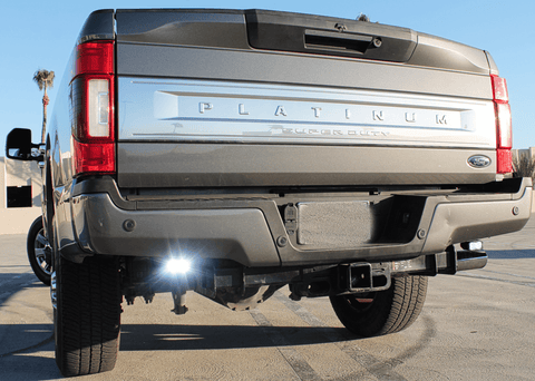 Ford Super Duty reverse light on 2020-2022 F250 F350 F450 rear view, chrome Ford badge, dual exhaust, lifted truck with flood reverse light