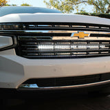 white 2021 2022 2023 2024 Chevrolet Suburban with one led white light bars behind the grille for off roading