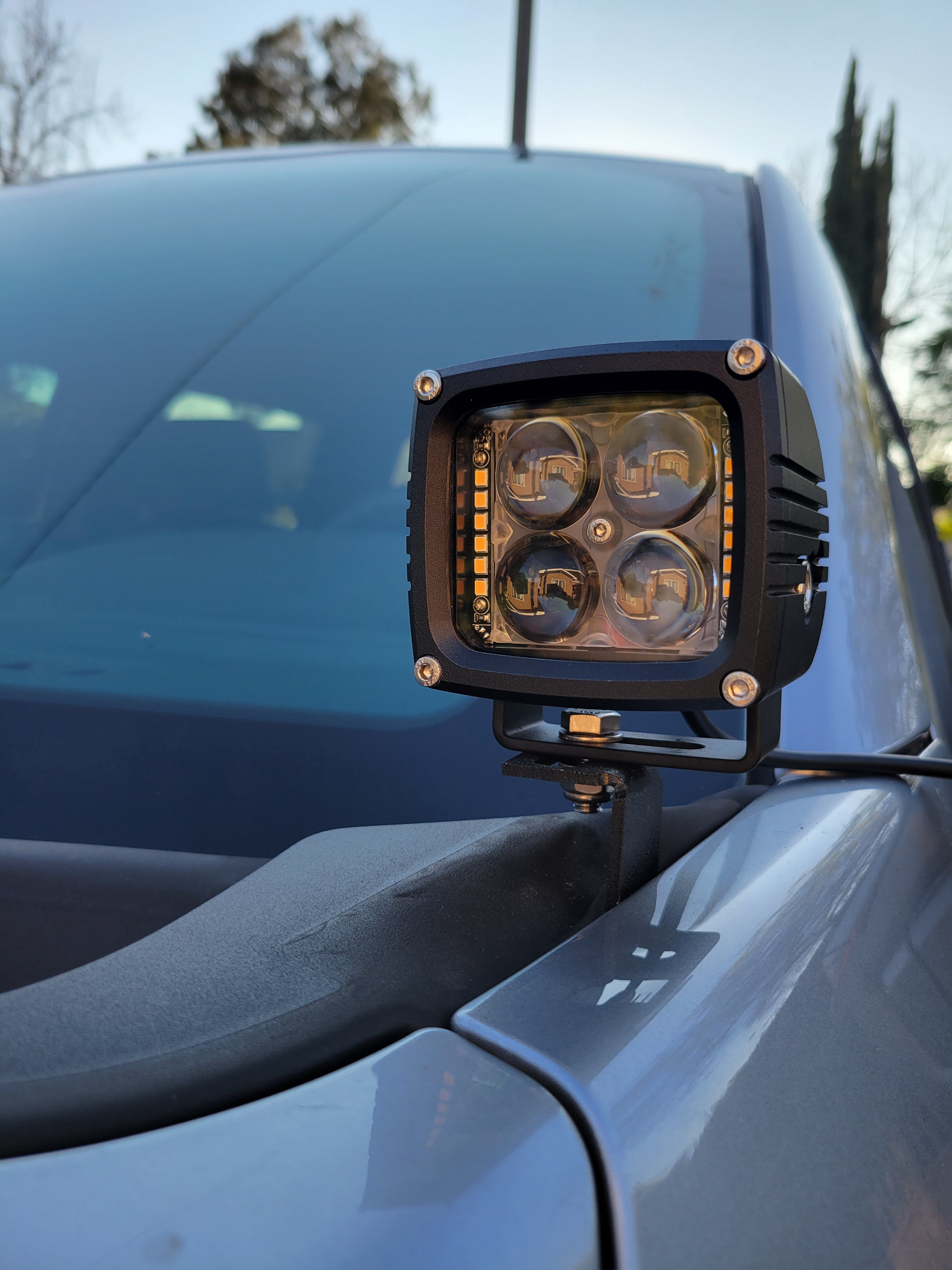 Ditch light LED pod installed on the hood mount bracket of a 2021-2023 Ford F150 next to the windshield