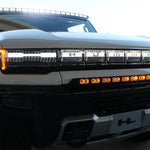white hummer ev with white roof light bar, amber drl bumper light bar and ditch lights