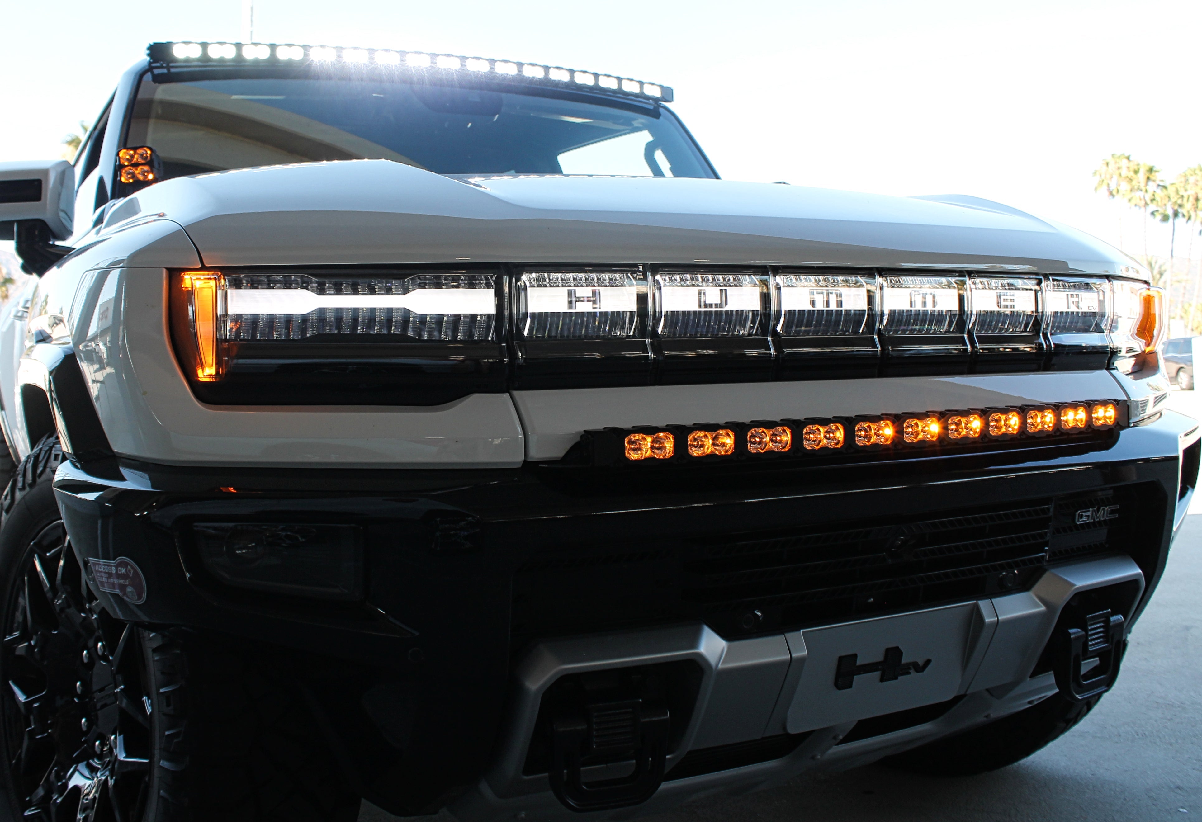 white hummer ev with white roof light bar, amber drl bumper light bar and ditch lights