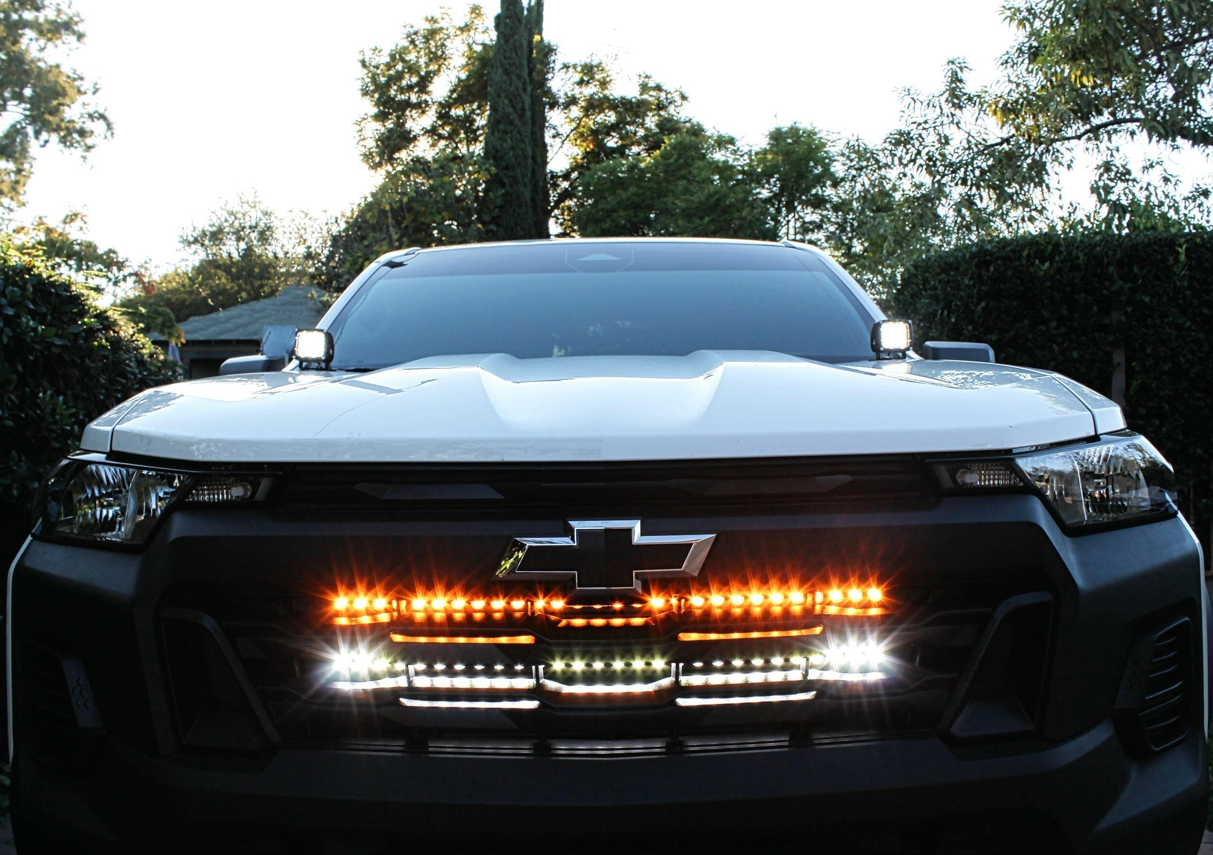 2023 2024 white chevrolet colorado with behind grille two lights bar and hood mount kit for off roading