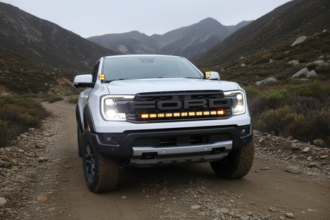 Ranger Raptor ditch lights. Dual color main white LED with amber DRL backglow on Ford Ranger Raptor with rugged off-road terrain