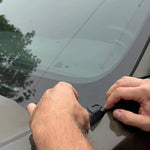 Hands installing hood mount for 2024 Ford Ranger Raptor, demonstrating accessory placement on vehicle.