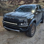 Ranger Raptor ditch lights installed on a dark Ford Ranger Raptor 2024+ with dual white and amber DRL glow in off-road terrain