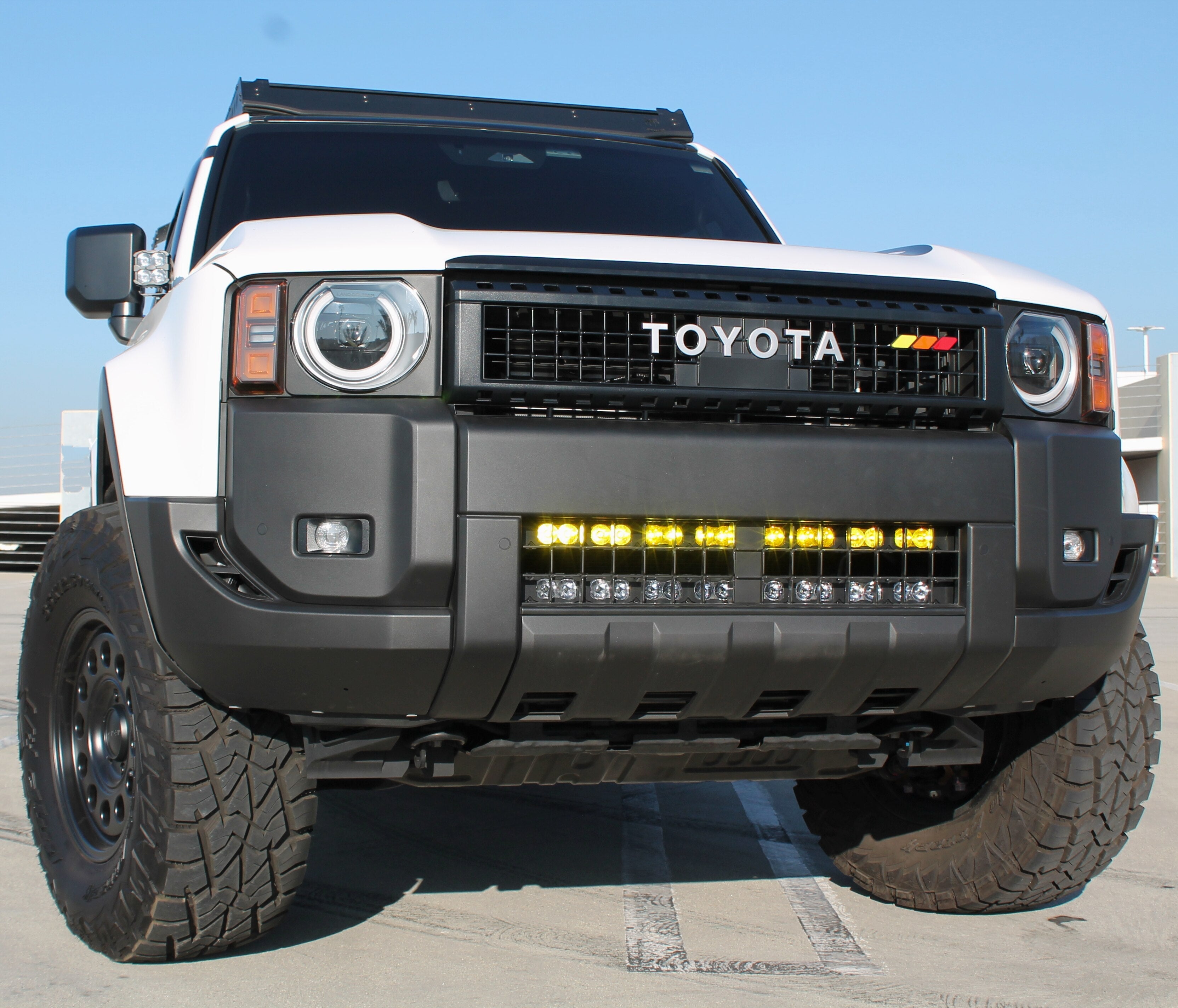 Land Cruiser light bar on 2024+ Toyota Land Cruiser with bold front grille and LED light bar, installed behind lower grille (does not affect radiator cooling)