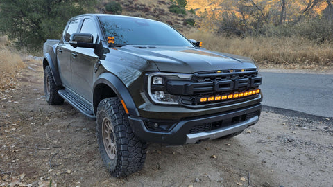 ford ranger raptor with amber light bar on top of grille and ditch lights