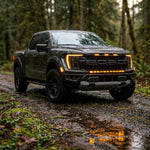 2024 Ford F150 Raptor with dual color light bar in amber, showcasing Ford F150 Raptor Light Bar features in a forest setting.