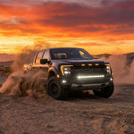 2024 Ford F150 Raptor with light bar driving in desert at sunset, showcasing Ford F150 Raptor Light Bar features.