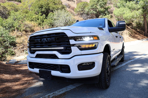 2025+ RAM 2500 light bar 40in slim curved LED installed on white RAM 2500 truck front grille on mountain road
