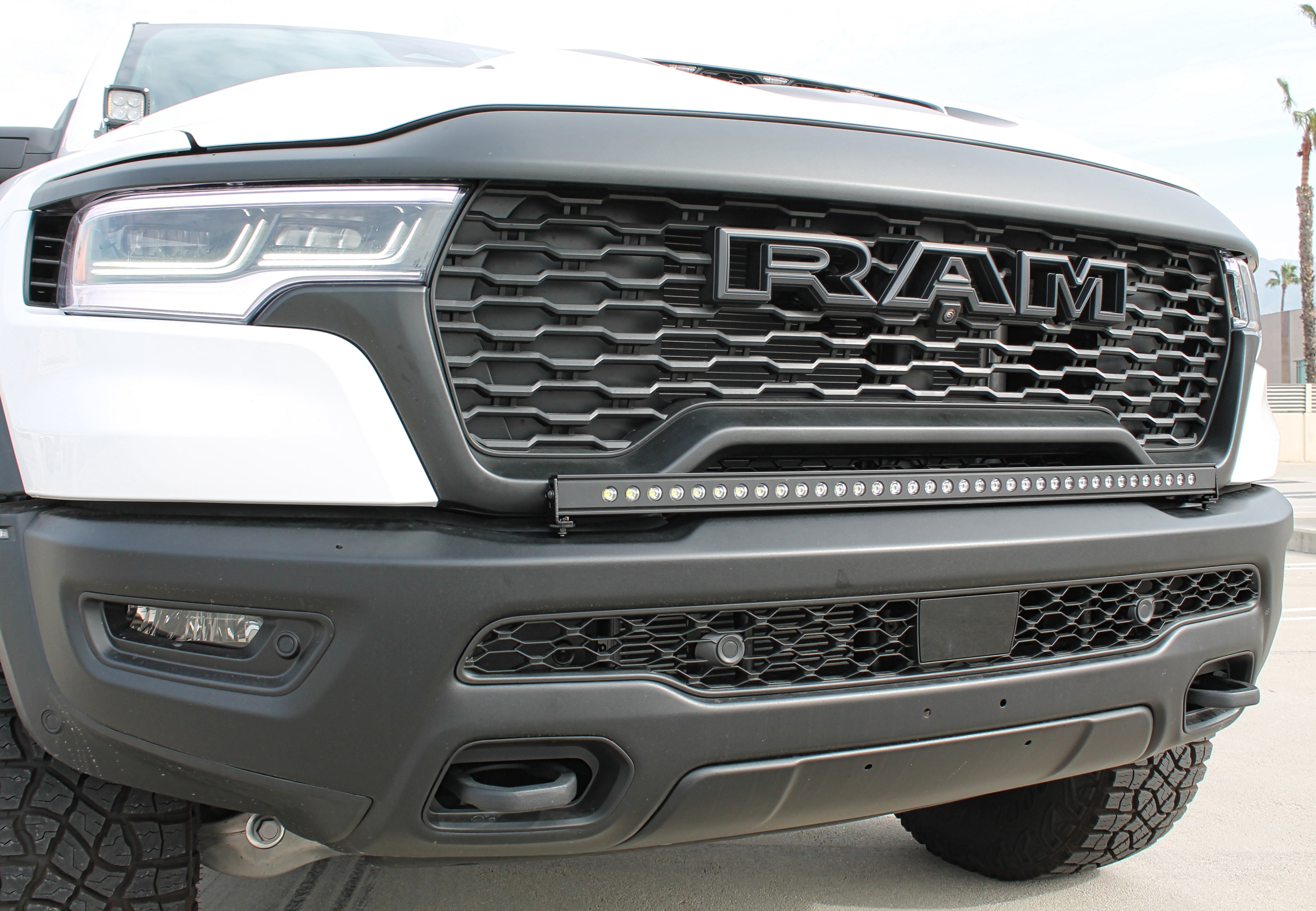 RAM RHO Lightbar on 2025+ RAM 1500 RHO with curved, slim bar following factory bumper curvature, black powder-coated bracket, no grille cutting required