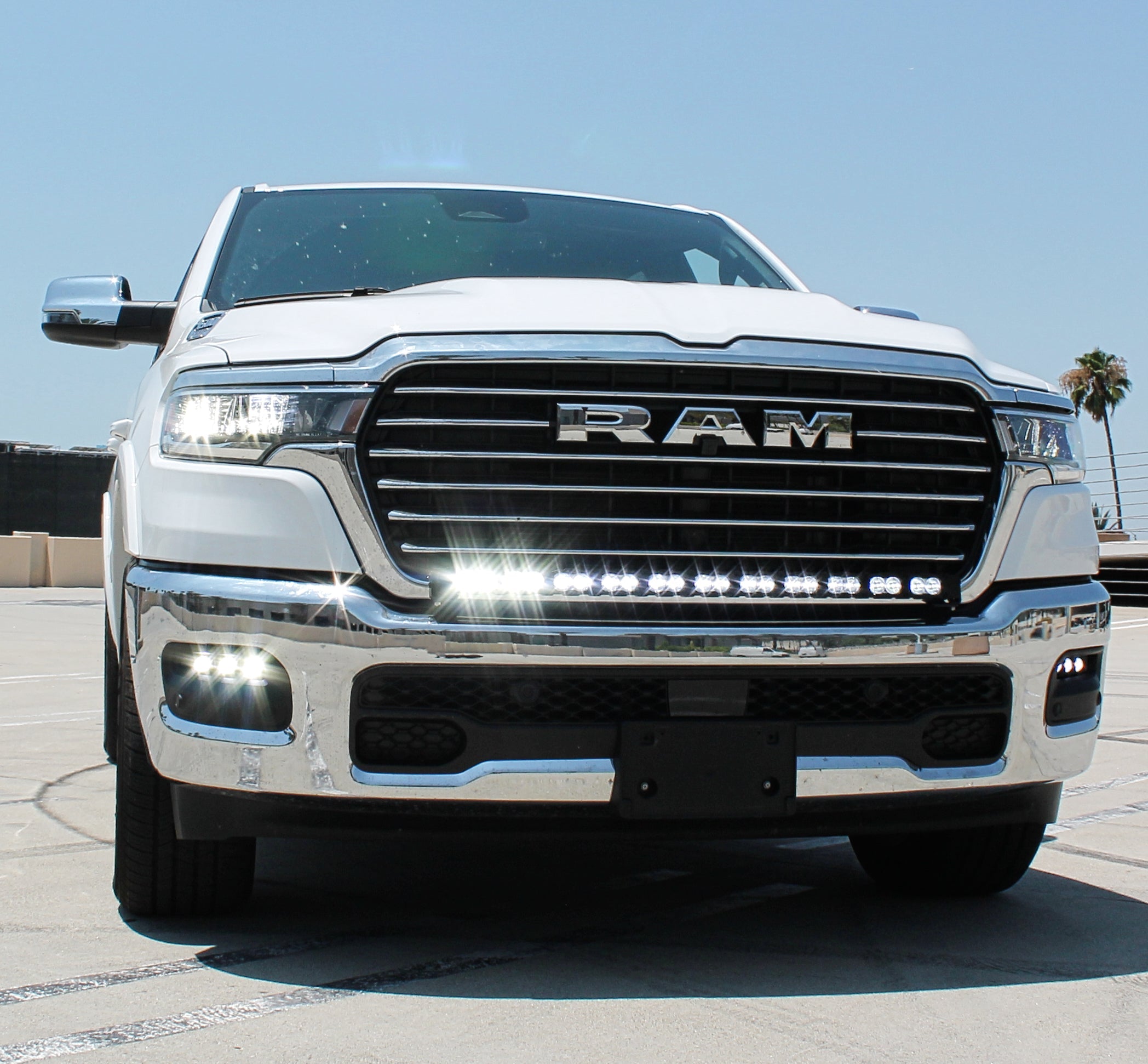 white 2025 ram 1500 with LED light bar on top bumper and fog lights