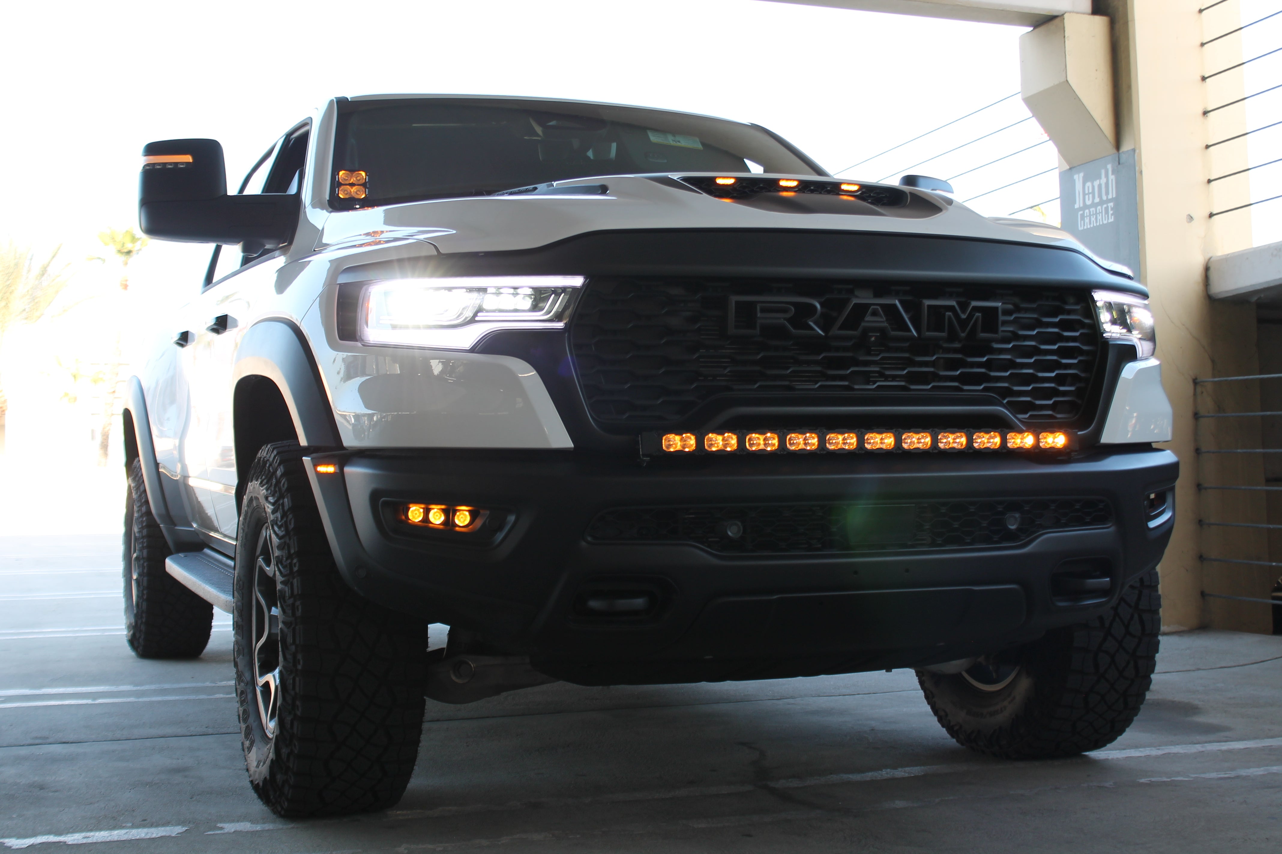 RAM RHO FOG on RAM 1500 RHO 2025+ front view with factory bolt-on fit, black powder-coated brackets, no cutting required (RAM RHO FOG)