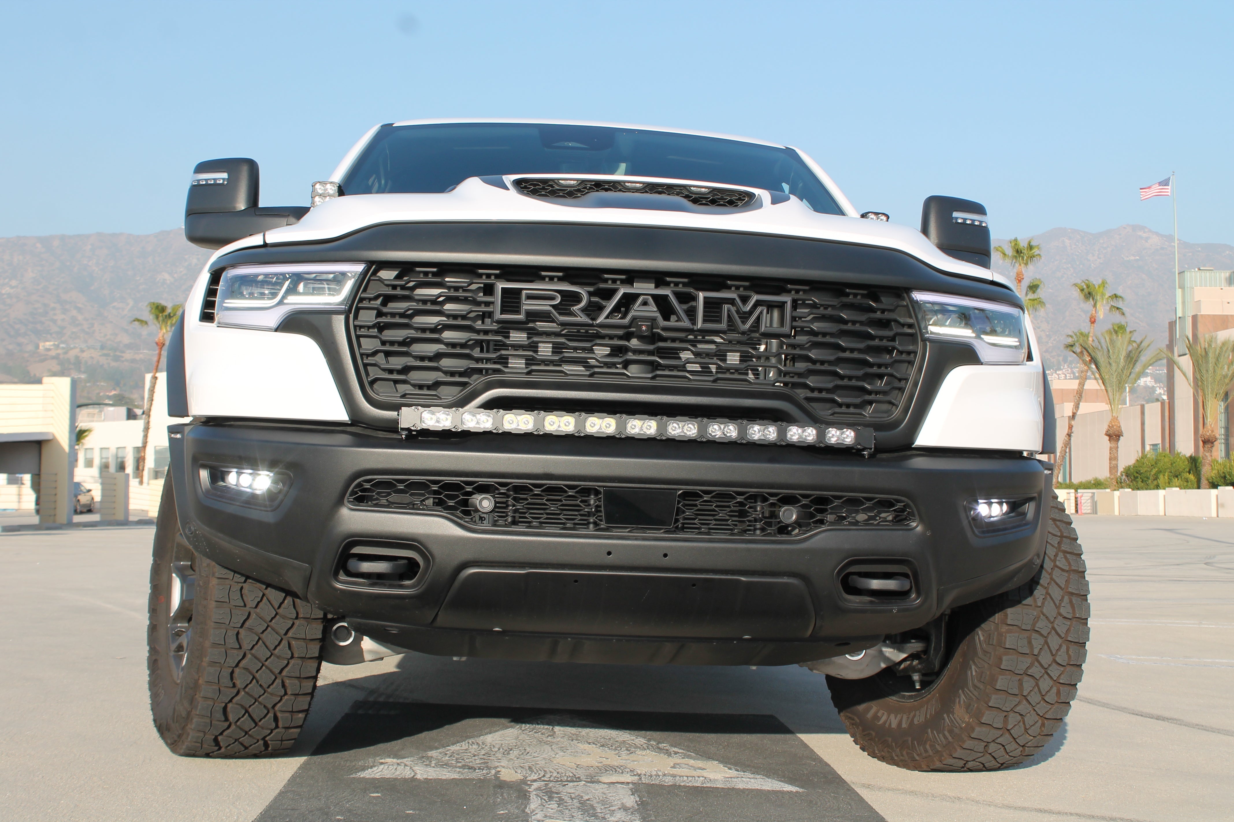 RAM RHO FOG light kit installed on 2025+ RAM 1500 with black powder-coated bracket and factory bolt-on fit