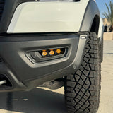 RAM RHO FOG Focus: Close-up of RAM 1500 with fog light kit installed, showcasing orange LED fogs and rugged tire profile