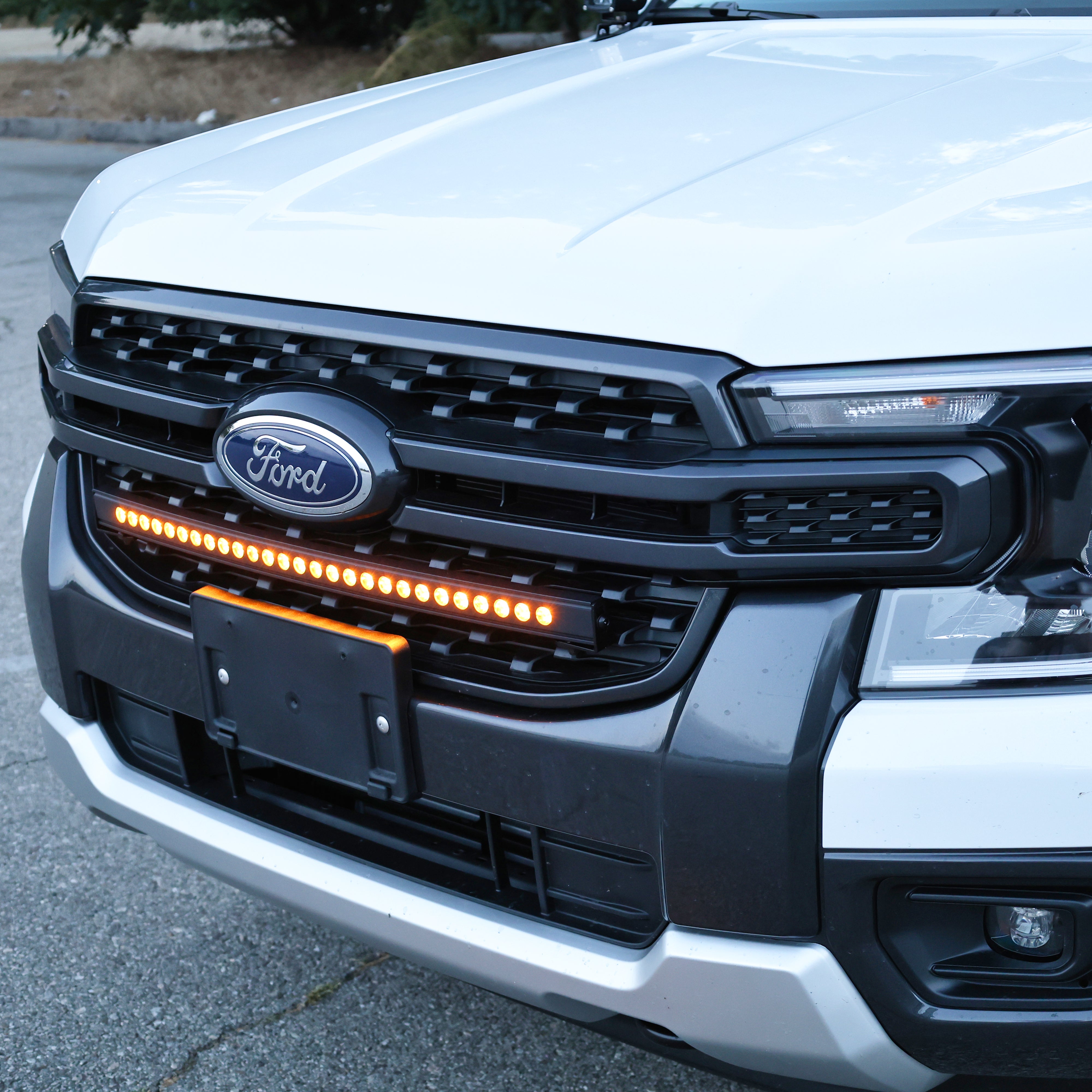Close-up of the 30-inch SLIM LED light bar in the front grille of a white Ford Ranger