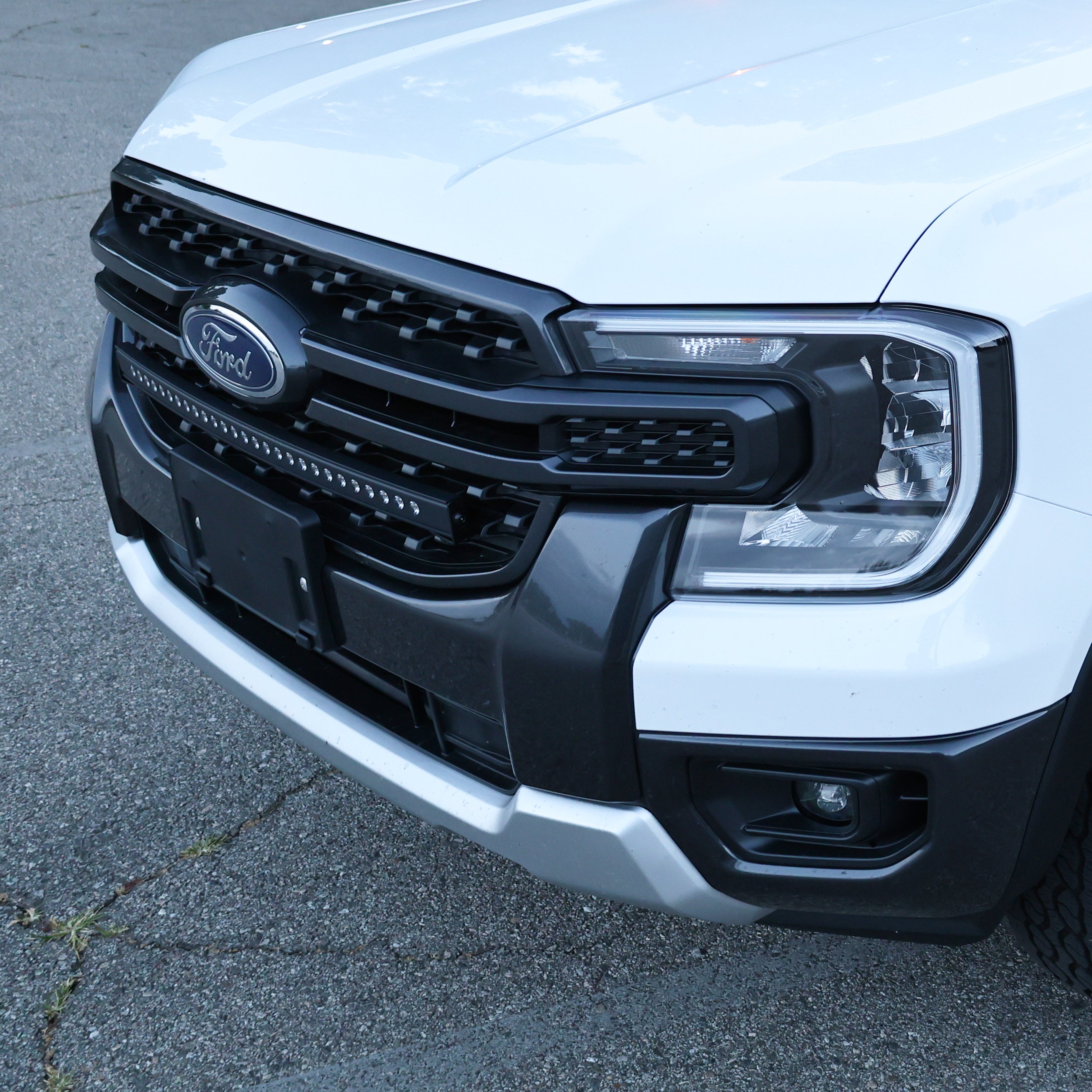 Front view of a white Ford Ranger highlighting the slim grille-mounted LED light bar