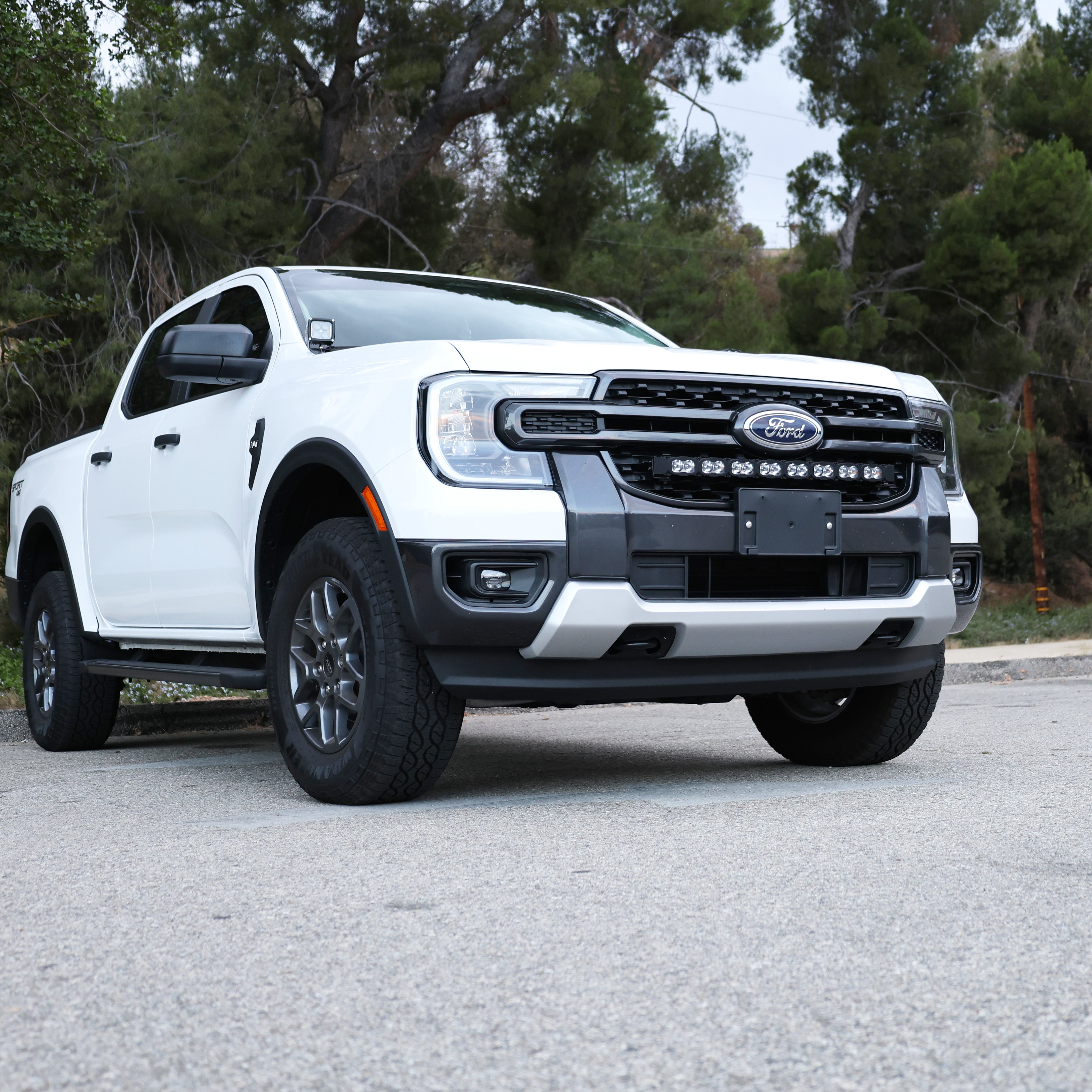 White Ford Ranger in a scenic outdoor setting with the grille-mounted 30-inch PRO LED light bar