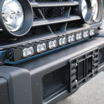 Ineos Grenadier round LED headlight and grille corner with 30in light bar bracket behind the grille