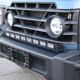 Light-blue Ineos Grenadier honeycomb grille with 30in bumper light bar mounted above, bolt-on kit