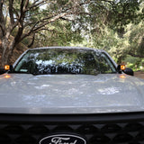 Ford Maverick Ditch Lights 2025+ amber dual color ditch lights illuminated on front mirrors in wooded road setting