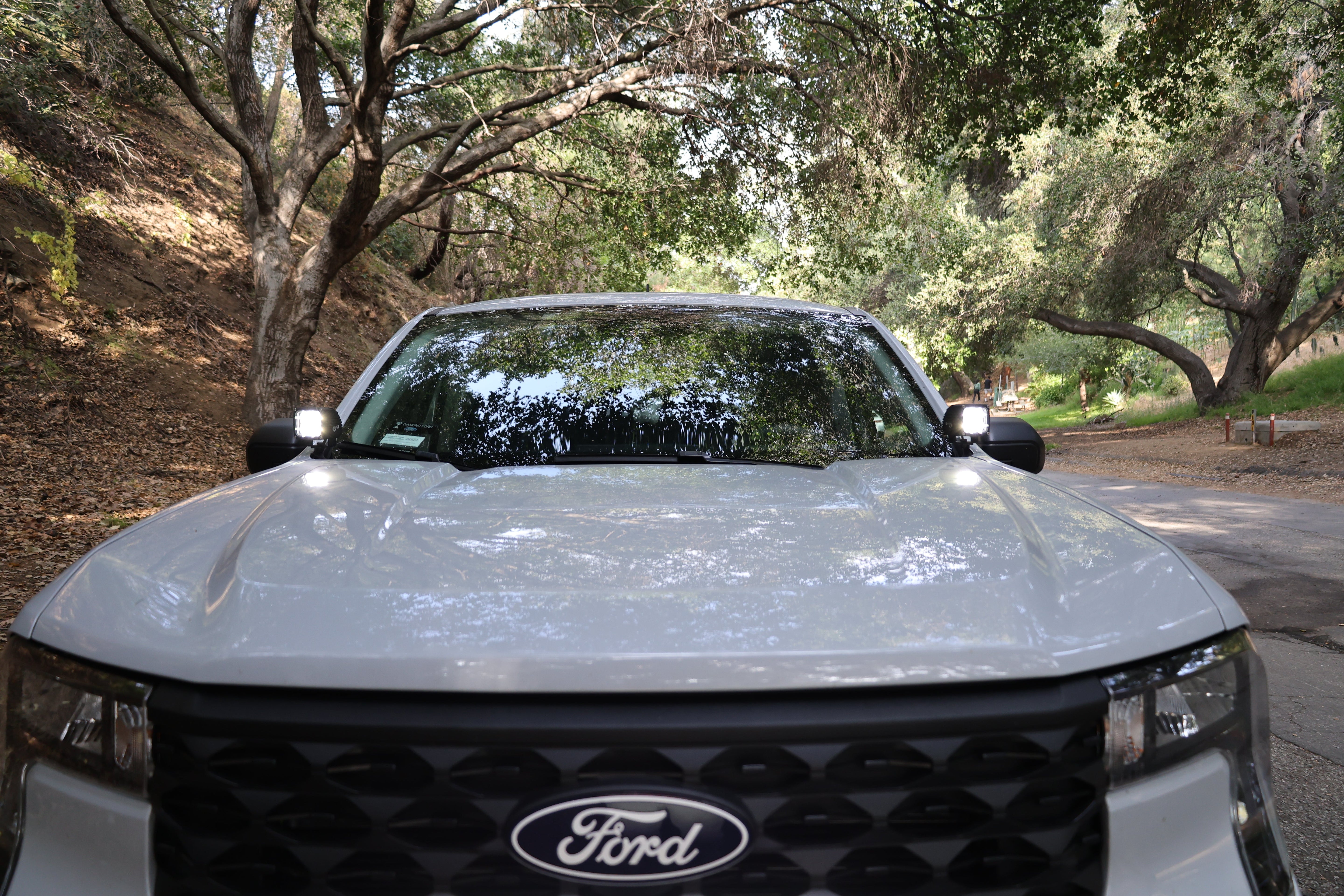 Ford Maverick Ditch Lights 2025 dual color ditch light kit installed on front of Ford Maverick truck in wooded road setting