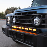 Ineos Grenadier 30in light bar lit in yellow across the front bumper at dusk, off-road driving lights