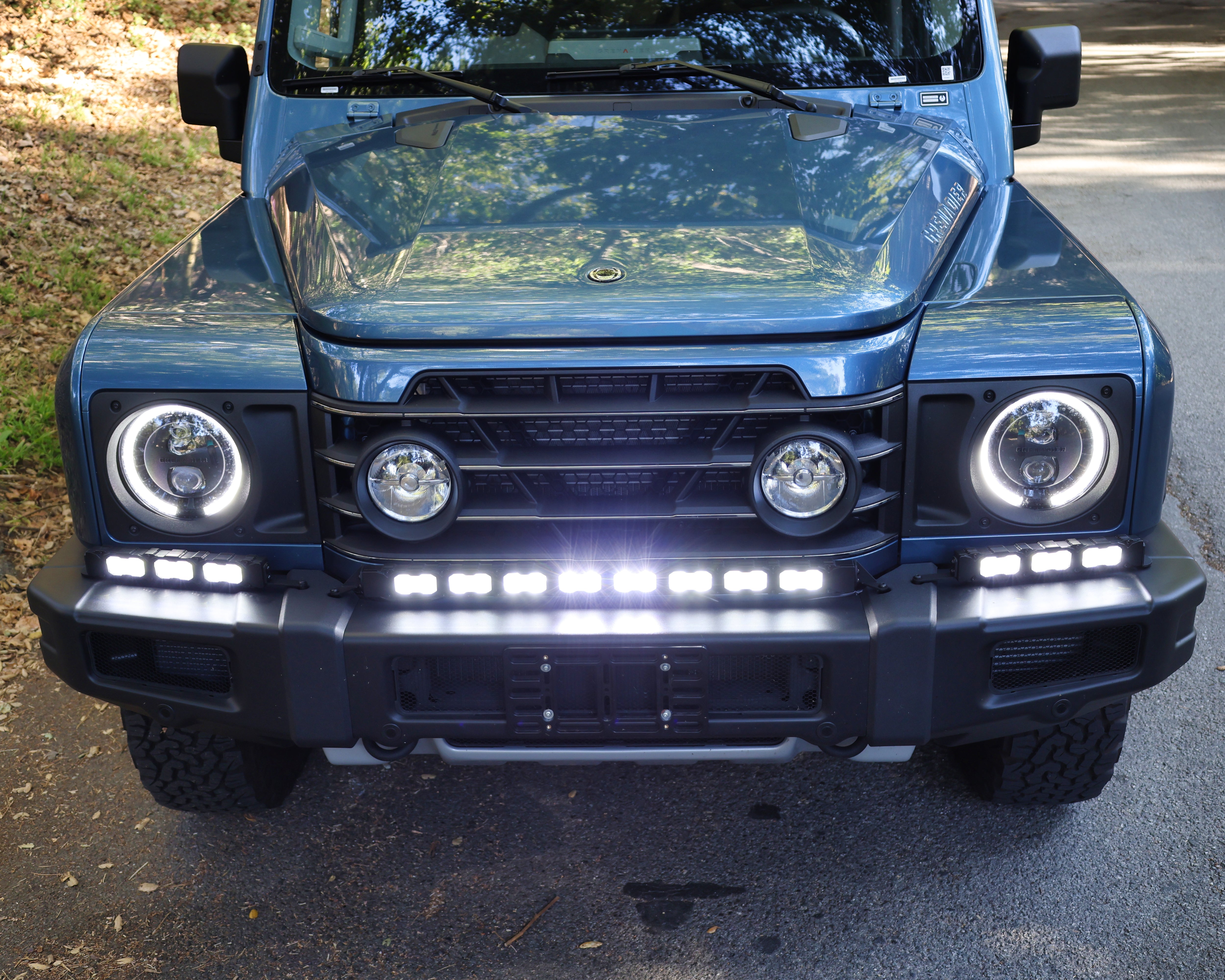 2024+ Ineos Grenadier front view with XL light bar kit lit white, 30in center bar and two 12in extension bars