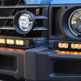 Close-up of the Ineos Grenadier XL light bar kit lit amber, 30in center bar meeting a 12in extension at the corner