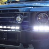 Ineos Grenadier front close-up with XL light bar kit lit bright white, 30in center bar and 12in extension