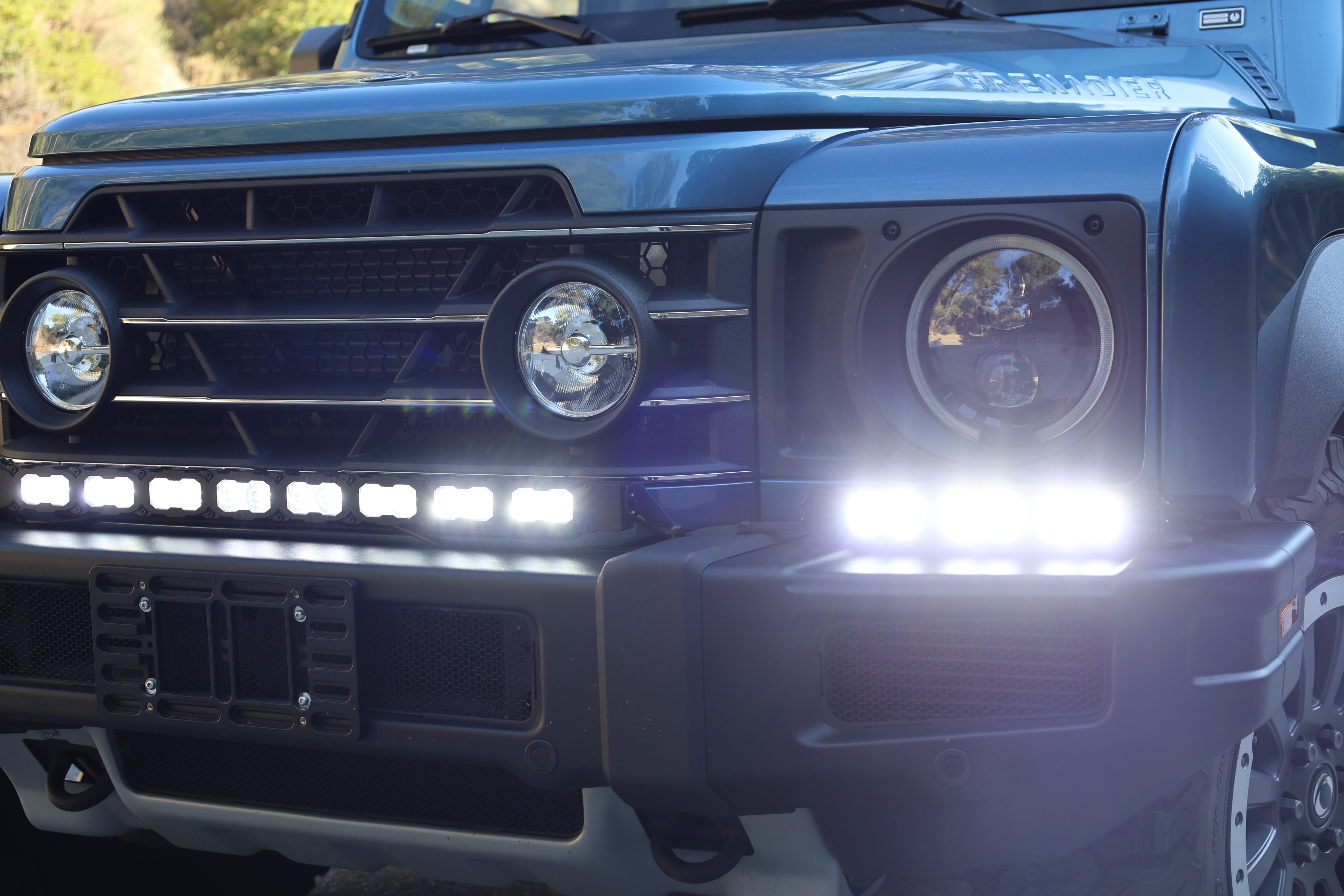 Ineos Grenadier front close-up with XL light bar kit lit bright white, 30in center bar and 12in extension