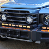 Ineos Grenadier front bumper with the XL light bar kit lit amber, 30in center bar and two 12in extensions