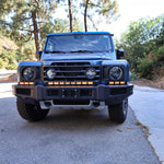 2024+ Ineos Grenadier front view with the full XL light bar kit lit amber across the bumper