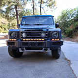 2024+ Ineos Grenadier front view with the full XL light bar kit lit amber across the bumper