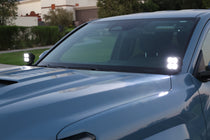 Close-up of illuminated white LED ditch lights mounted at the windshield cowl of a 2024+ Toyota Tacoma