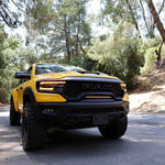 RAM TRX Light bar slim 23in installed in grille opening on yellow 2021-2024 RAM 1500 TRX on forest road