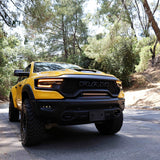 RAM TRX Light bar slim 23in installed in grille opening on yellow 2021-2024 RAM 1500 TRX on forest road